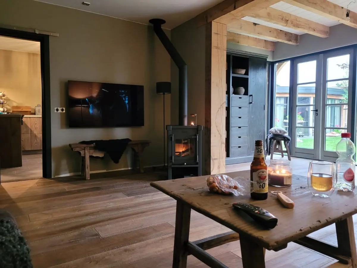 Interieur van een eiken bijgebouw met houtkachel en eiken balken