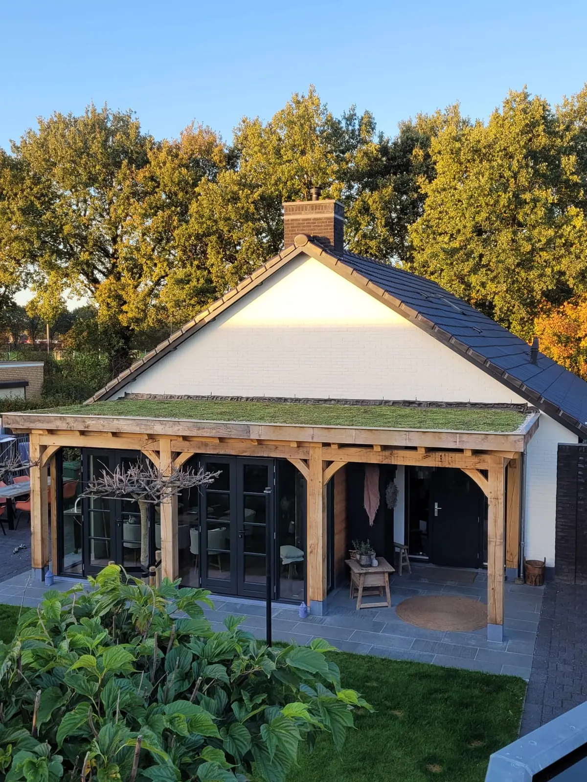 Eiken overkapping met groen dak bij zonsondergang