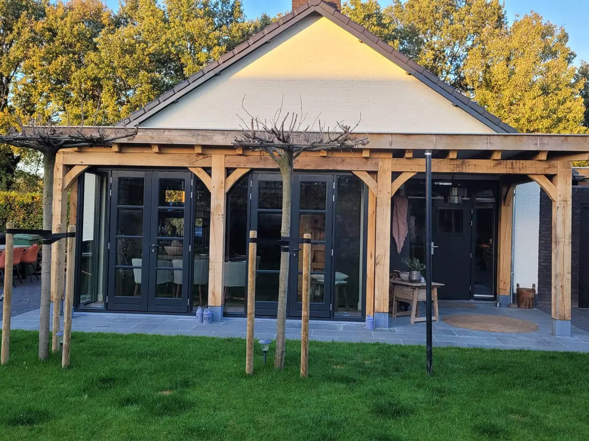 Eiken overkapping met tuindeuren in de herfstzon