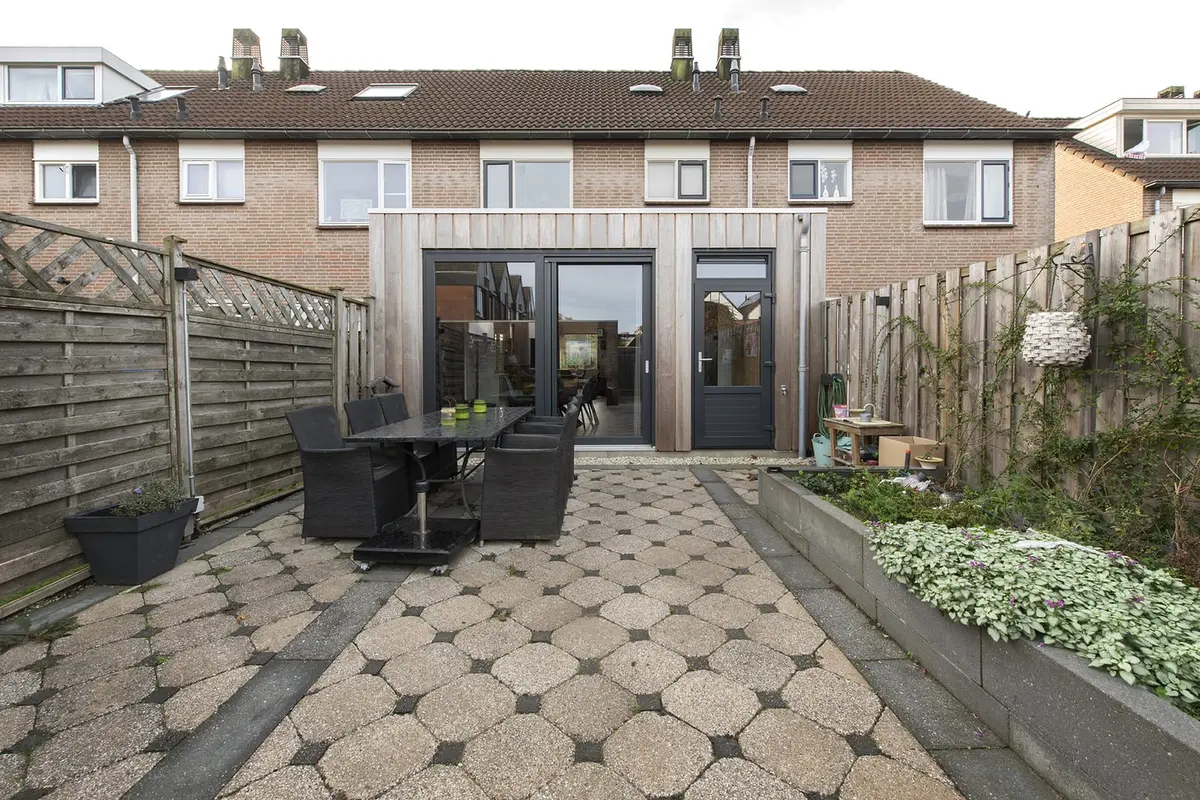Prefab aanbouw in Sleeuwijk gezien vanuit de tuin, met terras op de voorgrond