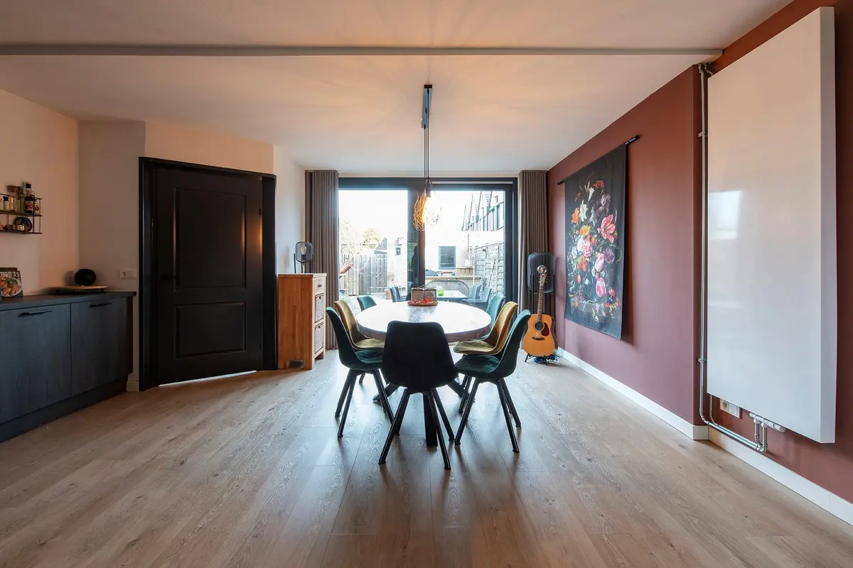 Eetkamer in de aanbouw in Sleeuwijk met eettafel, zwarte binnendeur en glazen pui naar de tuin