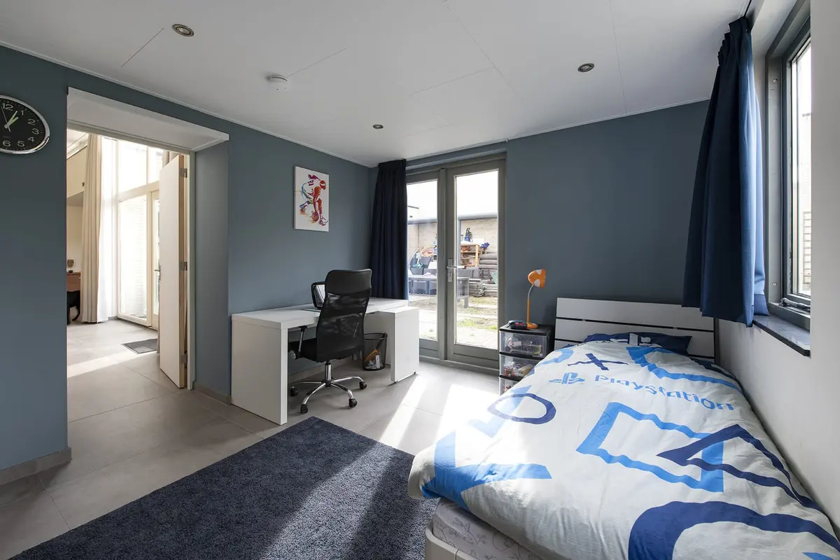 Slaapkamer in de zorgaanbouw met doorgang naar de woning